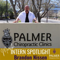 Brandon Nissen, Palmer West intern, in a white coat behind Palmer Chiropractic Clinics pillar.