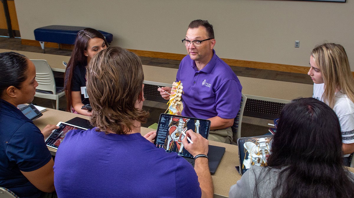 Anatomy instructor teaching a group of chiropractic students