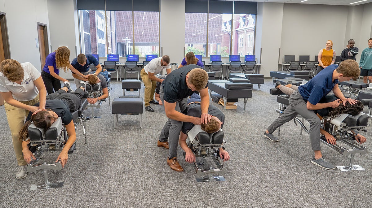 Students practicing chiropractic technique in class