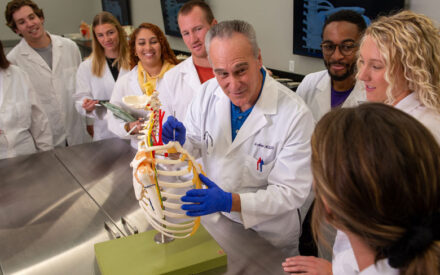 group of students observing instructor using spine model.
