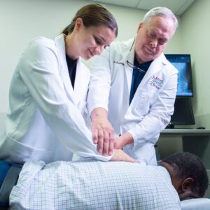 Dr. Krayenhagen and student adjusting patient.