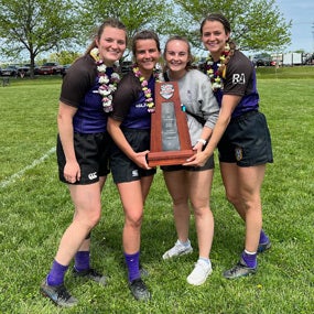 Allison David and members of the Rugby team holding trophy.