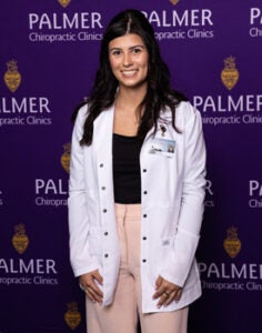 Cheyanne Schmaltz in white clinic coat against Palmer background.