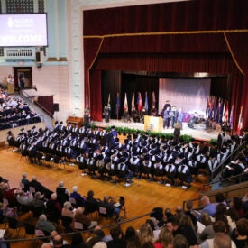 Overview shot of Main Campus graduates in caps and gowns.